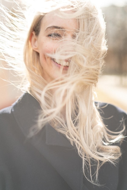 Retrato em close-up de uma jovem sorridente com o cabelo desarranjado
