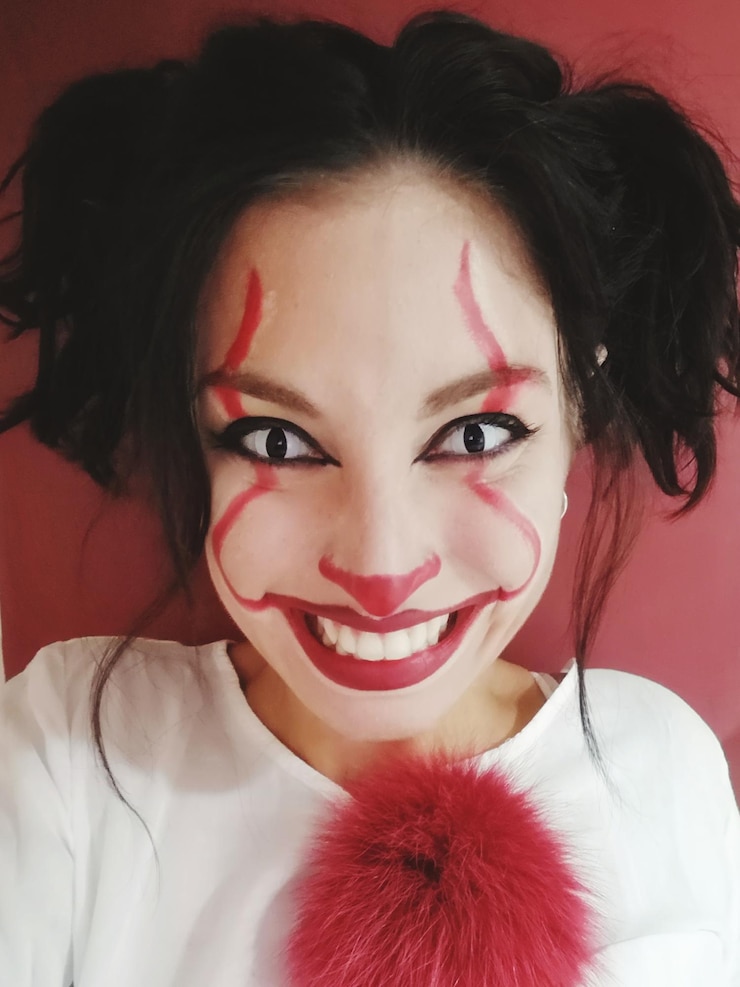 Foto retrato em close-up de uma jovem sorridente usando maquiagem contra a parede