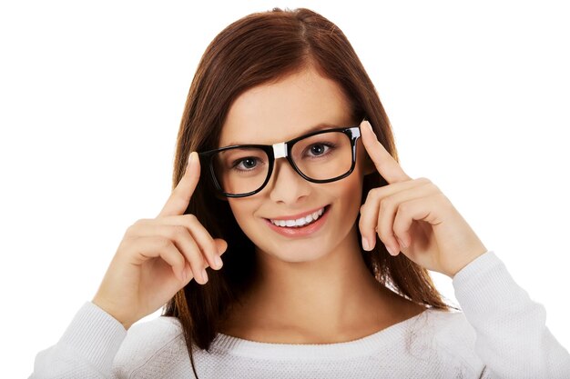 Foto retrato em close-up de uma jovem sorridente usando óculos contra fundo branco