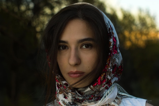 Foto retrato em close-up de uma jovem usando um lenço no parque