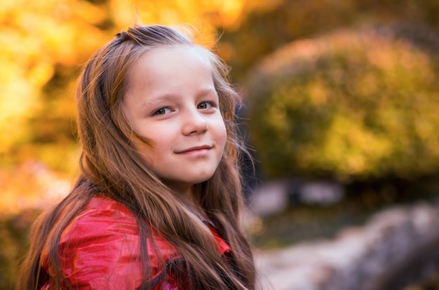 Retrato em close-up de uma menina bonita no parque durante o outono