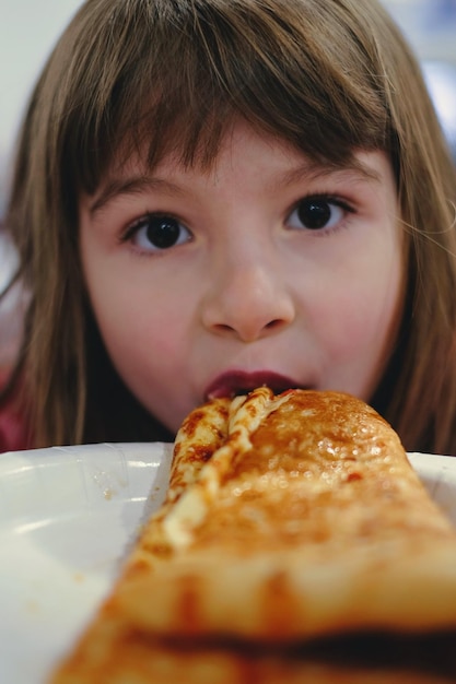 Foto retrato em close-up de uma menina comendo comida