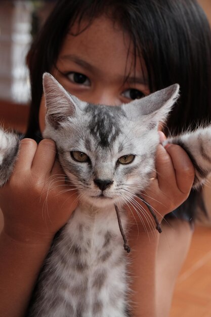 Foto retrato em close-up de uma menina segurando um gatinho