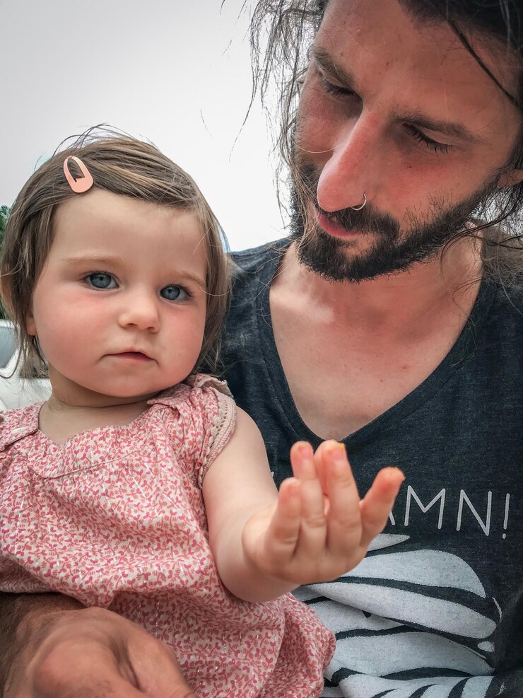 Foto retrato em close-up de uma menina sentada com o pai ao ar livre