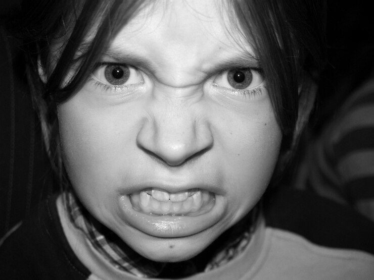 Foto retrato em close-up de uma menina zangada apertando os dentes à noite