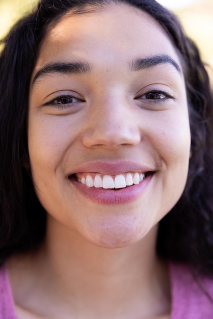 Foto retrato em close-up de uma mulher biracial feliz na natureza ensolarada