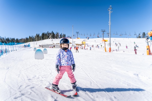 Retrato em comprimento completo de um menino em uma paisagem coberta de neve