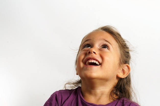 Foto retrato em fundo branco de uma menina italiana de 4 anos de idade, olhando para cima