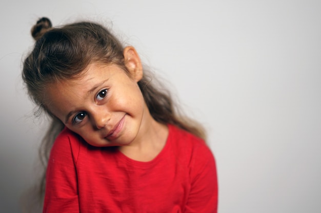 Retrato em fundo branco de uma menina italiana de 4 anos, olhando de soslaio