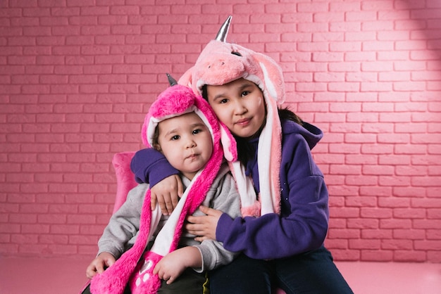 retrato emocional de duas garotas asiáticas em trajes de halloween em fundo rosa