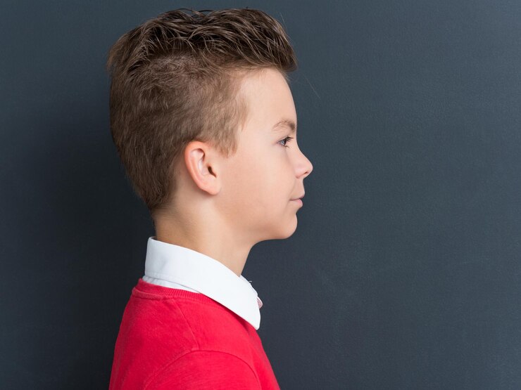 Foto retrato emocional de um menino adolescente caucasiano olhando para longe perfil de uma criança bonita na frente de um grande quadro