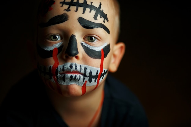 Retrato emocional de um menino com um zumbi assustador no rosto