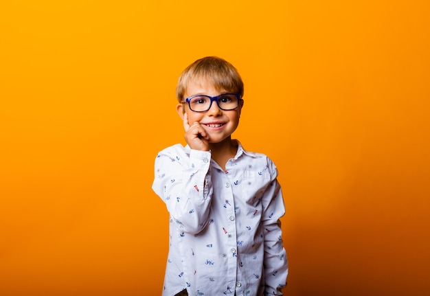 Retrato emocional de um menino de óculos. Uma criança surpresa olha para a câmera.