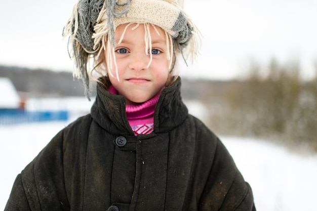 Retrato emocional de la niña eslava positiva vistiendo chaqueta acolchada holgada con bufanda