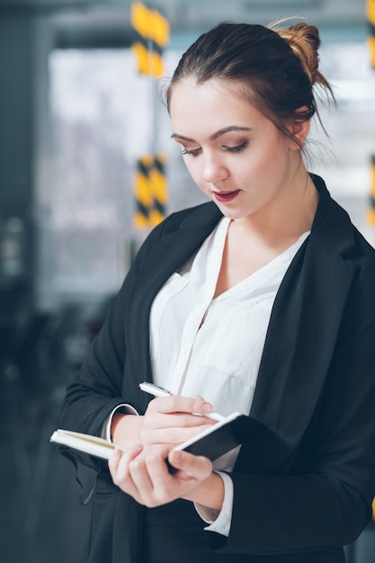 Retrato de empleado de la empresa. Los negocios importan. Joven pasante haciendo notas en el planificador diario.