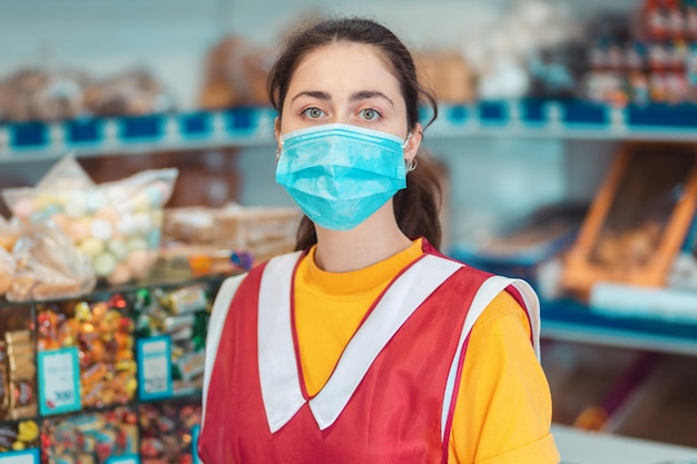 Retrato de un empleado en uniforme, con una máscara médica en su rostro. Concepto de medidas preventivas durante la pandemia de coronavirus.