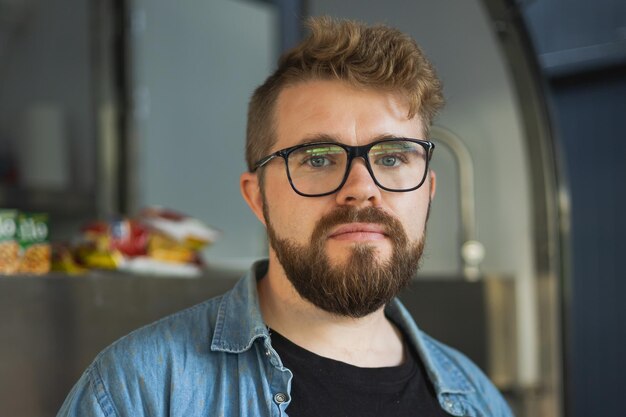 Retrato de un emprendedor creativo serio sonriendo en un lugar de trabajo moderno mirando a la cámara Hombre independiente milenario barbudo en la oficina