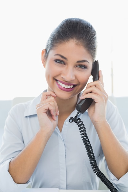 Retrato de una empresaria alegre que usa el teléfono