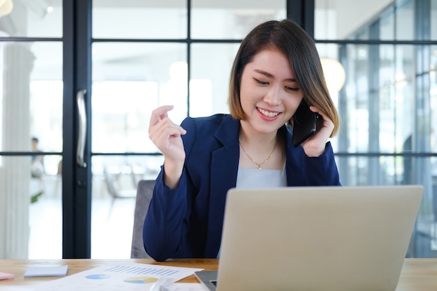 Retrato de empresaria joven hermosa e inteligente que trabaja en la estación de trabajo moderna.