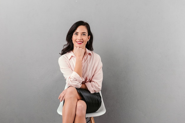 Retrato de una empresaria sonriente sentada en una silla