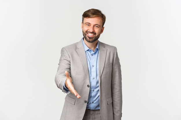 Retrato del empresario barbudo sonriente y confiado, estirando la mano