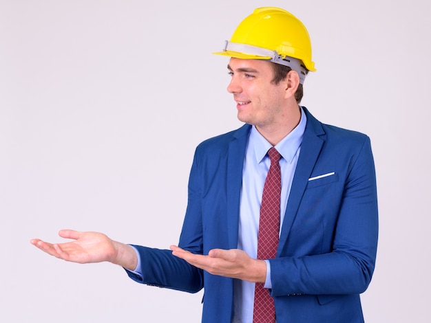 Retrato del empresario como ingeniero vistiendo hardhat en blanco