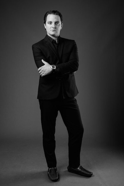 Retrato del empresario italiano vistiendo traje negro sobre gris en blanco y negro
