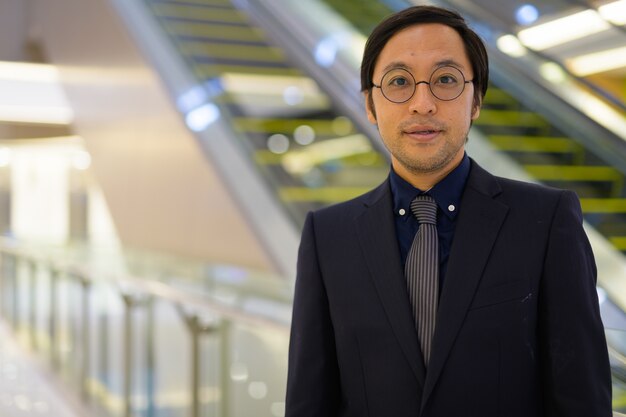 Foto retrato del empresario japonés que trabaja dentro del edificio de oficinas