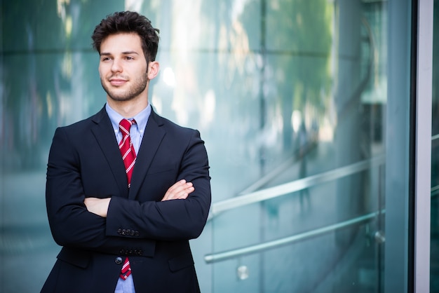 Retrato de un empresario sonriente delante de un fondo moderno azul