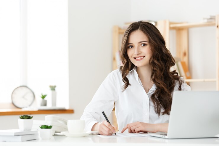 Foto retrato de una encantadora empresaria sentada en su lugar de trabajo y escribiendo