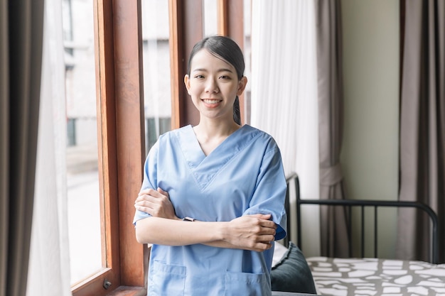 Retrato de una enfermera asiática que usa batas médicas en la casa del paciente Visita del cuidador en el hogar Concepto de cuidado de la salud en el hogar y hogar de ancianos