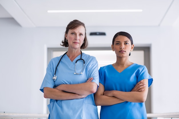 Retrato de enfermera y médico de pie con los brazos cruzados