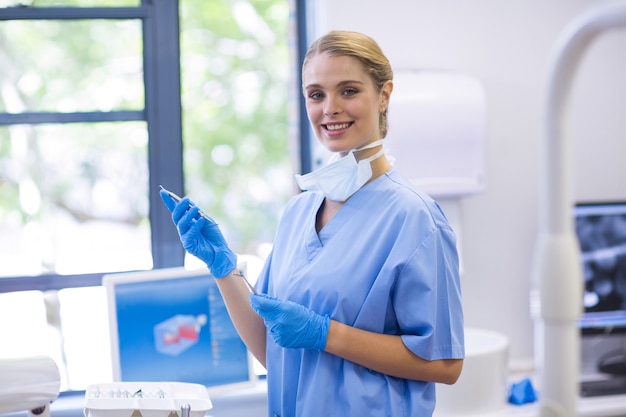 Retrato de enfermera sosteniendo herramientas dentales