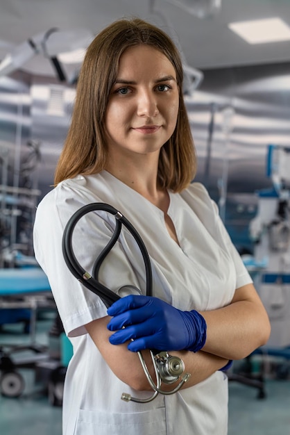 Retrato de enfermera en uniforme blanco y estetoscopio en quirófano en el hospital