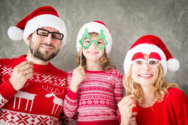 Retrato engraçado de família feliz com adereços de papel de Natal