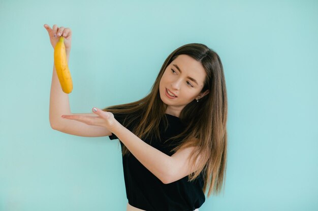 Retrato engraçado de jovem com banana na cor de fundo