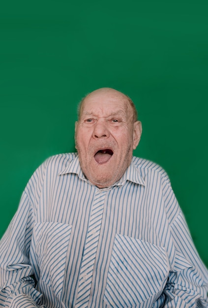 Retrato engraçado de um homem idoso em um fundo verde
