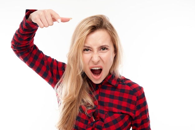 Retrato enojado joven rubia gritando aislado sobre fondo blanco studio mostrando emociones negativas