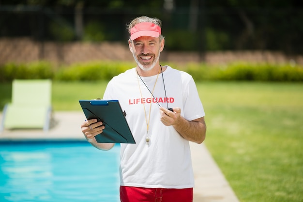 Retrato de entrenador de natación con cronómetro y portapapeles cerca de la piscina