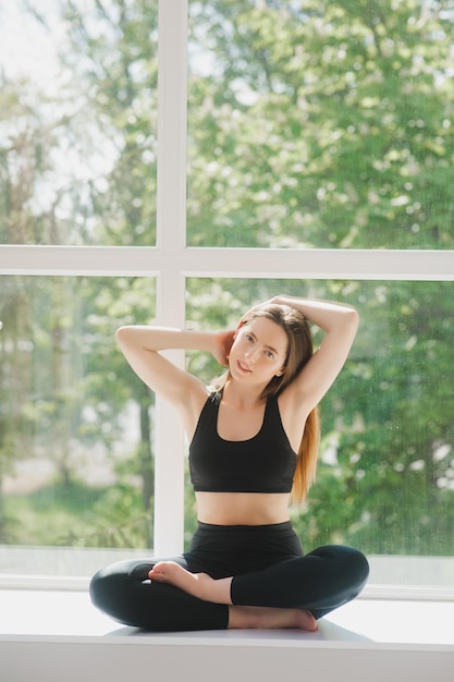 Retrato de una entrenadora de fitness corporal relajándose entre el ejercicio en el gimnasio