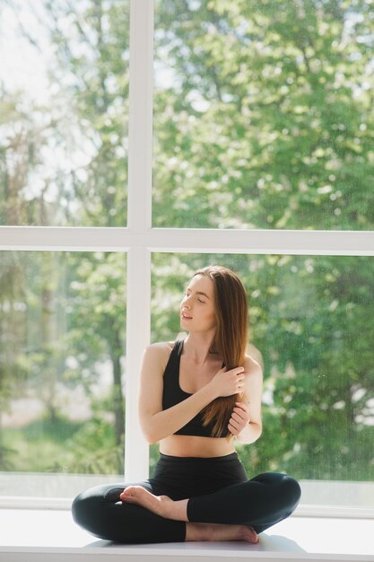 Retrato de una entrenadora de fitness corporal relajándose entre el ejercicio en el gimnasio