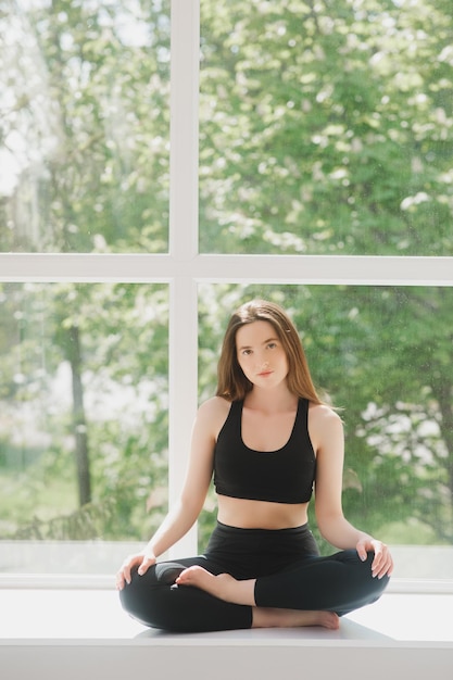 Retrato de una entrenadora de fitness corporal relajándose entre el ejercicio en el gimnasio