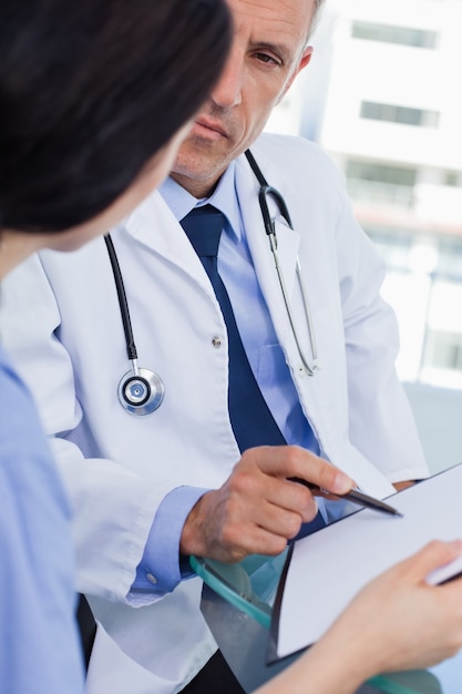 Retrato de un equipo médico enfocado mirando un documento