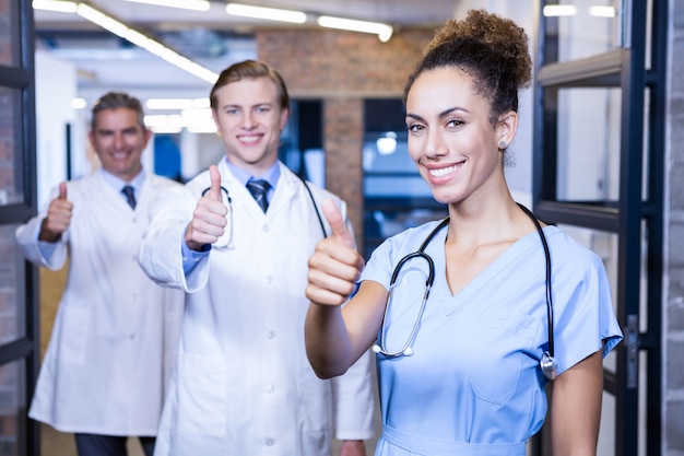 Retrato del equipo médico levantando los pulgares y sonriendo