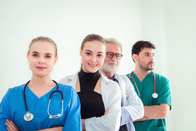 Foto retrato de un equipo médico sonriente de pie contra la pared