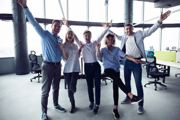 Retrato de equipo de negocios creativos de pie juntos y riendo. Empresarios multirraciales juntos al inicio.