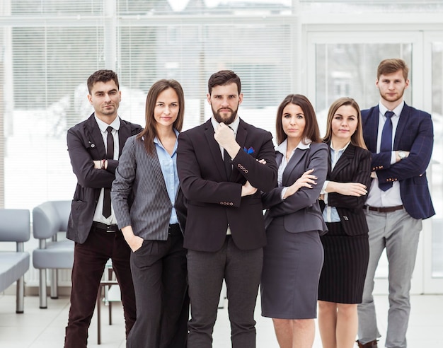 Retrato de un equipo de negocios muy unido parado uno al lado del otro en el vestíbulo de la oficina