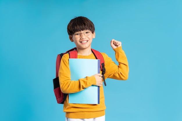 Retrato de un escolar asiático nacido en un fondo azul