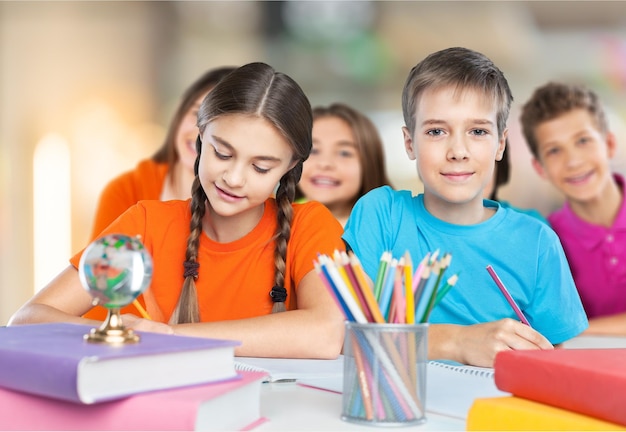 Retrato de escolares felices dibujando con lápices de colores