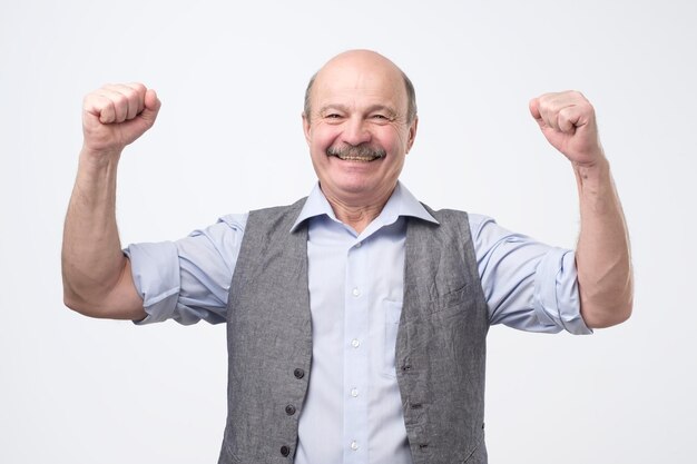 Retrato de un español feliz con los puños en alto celebrando su victoria